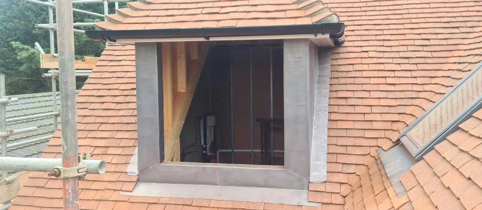 Dormer leadwork with UPVC guttering on a clay tile roof, Surrey