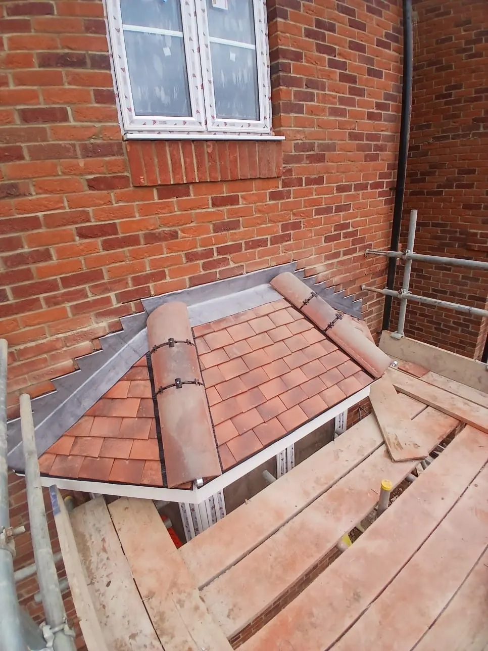 Clay tile bay roof with lead flashing against brickwork, Bracknell