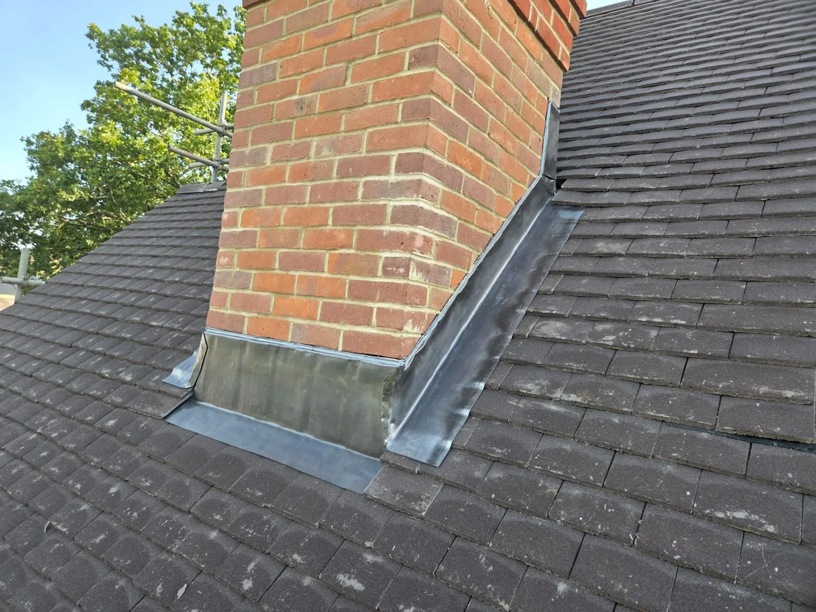New lead flashing around a brick chimney on a tiled roof, Bracknell